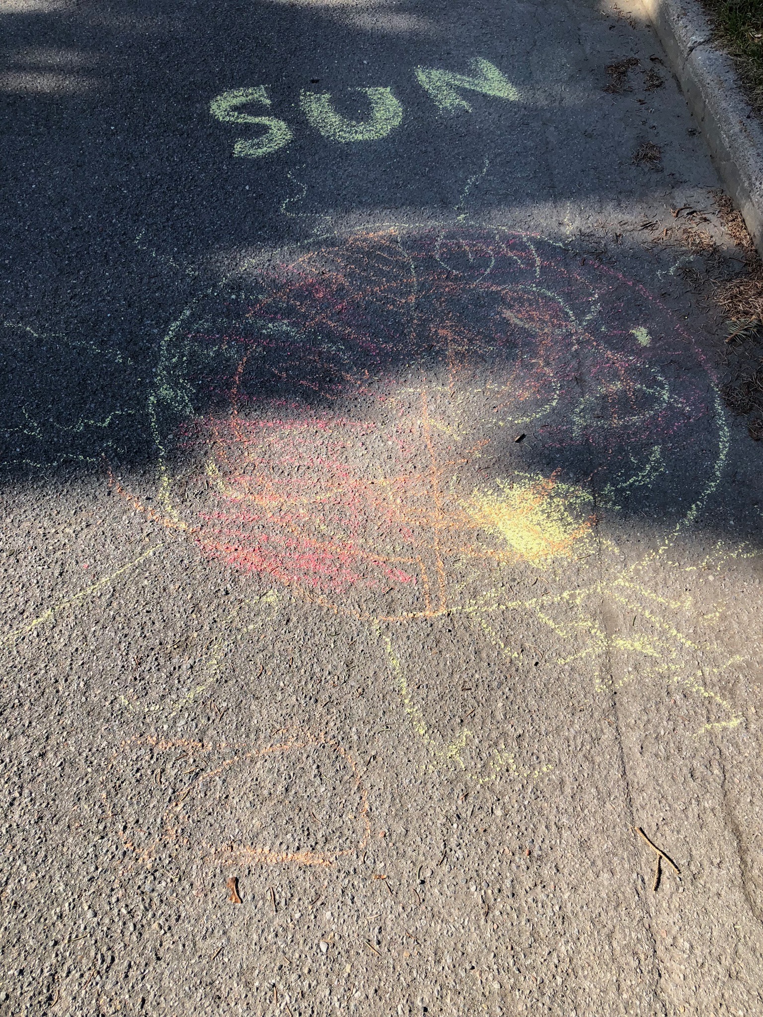 A chalk drawing of a sun with the label "sun". The sun is filled with yellow, orange, and red swirls.